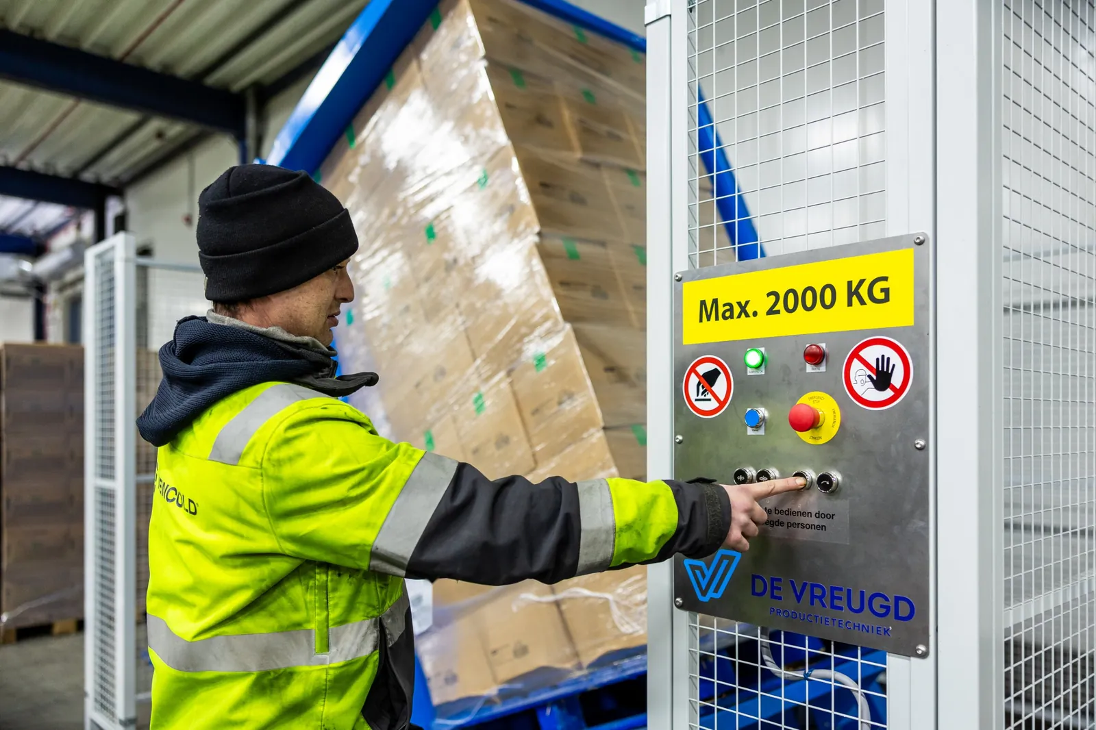 Un employé utilise le retourneur de palettes PalletRotator K11 pendant que la palette bascule